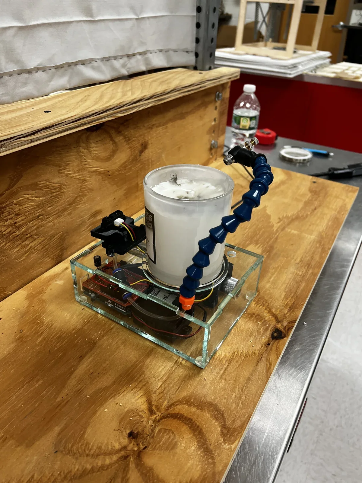 Candle Safe prototype with plexiglass housing, candle, and CO₂ delivery arm